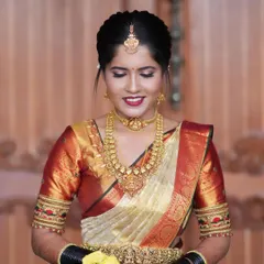 The complete bridal look, showing the elegant updo, jewellery, and the classic drape of the silk saree with a waist belt (vaddanam).