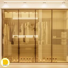 A stunning walk-in closet with gold-tinted glass sliding doors and internal lighting. This design allows you to see your collection while keeping it protected and organized.