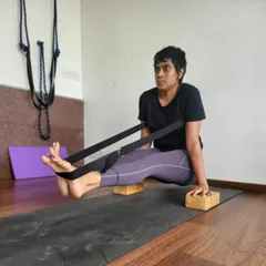 A student practices Brahmacharyasana using blocks and a strap. This challenging arm balance requires immense core and arm strength. Props provide the necessary support and stability to build confidence and work towards the full expression of the pose.