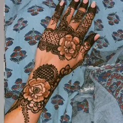 This is one of my favorite styles, combining large, shaded roses with delicate leafy vines and geometric patterns on the fingers. It's a perfect example of modern Arabic fusion henna.