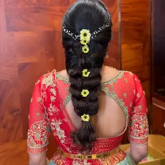 A creative take on a traditional braid. This bubble braid is adorned with small, delicate sunflowers for a fresh and unique look.
