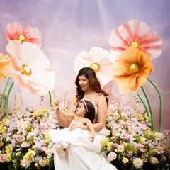 A quiet moment in a field of flowers. The mother and daughter sit together in our dreamy floral setup, sharing a special connection in a beautiful, serene environment.