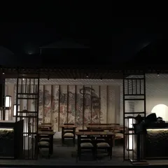 A frontal view of the entire Ebisu pop-up structure at night. The design includes a latticed roof, clean wooden frames, and a large, traditional Japanese mural as a backdrop for the dining area.