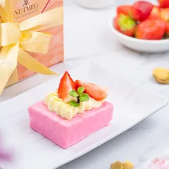 A dessert shoot for a gourmet shop, featuring a delicate strawberry pastry. The styling is clean and bright, with a marble background and fresh strawberries to emphasize the quality and craftsmanship of the dessert.