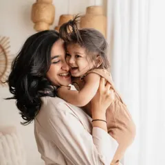 A heartwarming photo of a mother and daughter sharing a hug and a laugh, showcasing their close bond.