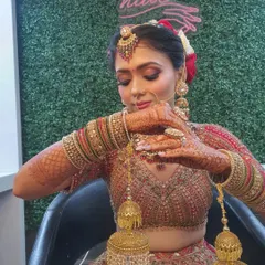 The final touches are everything. This bride is adjusting her kalire, showing off her intricate henna and the complete look with jewellery, hair, and flawless makeup.