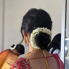 You can never go wrong with a classic low bun, especially when it's wrapped in a fragrant jasmine gajra. I make sure the bun is neat and voluminous, creating a timeless and elegant look that is perfect for any traditional wedding ceremony.