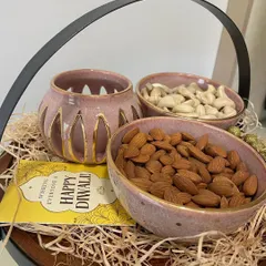 A closer view of the Diwali hamper, showing the delicate gold detailing on the rim of the bowls and the cutouts of the tealight holder. These are luxurious yet personal gifts.