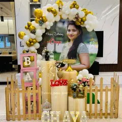 We can make your celebration extra personal. For this event, we designed a setup around a large custom portrait of the mom-to-be, framed by a white and gold balloon arch, a picket fence, and light-up letters spelling her name.