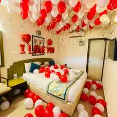 A slightly different angle of the classic red and white anniversary decoration, showing the heart-shaped foil balloons that add to the romantic theme.