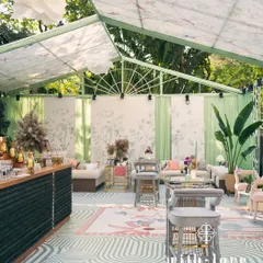 An overview of our 'Conservatory' themed baby shower. The custom-built structure with botanical print ceilings, sage green walls, and modern furniture creates a chic, light-filled, and serene environment for celebration.