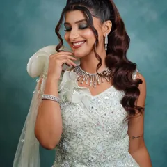 A glamorous high ponytail with soft, face-framing curls. This cocktail look is all about drama and sophistication, perfect for a bride who wants to make a statement at her reception or sangeet.