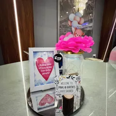A personalized welcome display for the parents-to-be. We combined a custom welcome sign with a framed message and a decorative jar topped with a teddy bear, creating a warm and inviting first impression for guests.