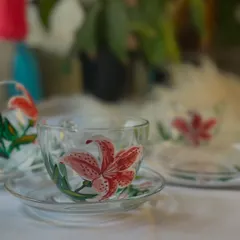 This is our Stargazer Lily design, hand-painted on a clear glass teacup and saucer. The vibrant pink and detailed petals make every sip feel a little more special.