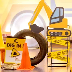 Dig in. I use a variety of props to create an authentic construction site feel, including excavator cutouts, orange traffic cones, real tires, and caution tape wrapped around the decor.
