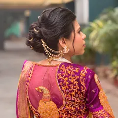 This side angle highlights the beautiful texture of the bun and how the chained earring accessory connects seamlessly to the hairstyle.