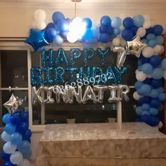 A simple yet elegant birthday setup at home, using a foil balloon banner and a blue and white balloon frame.