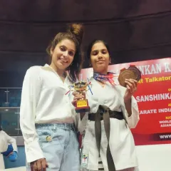 Two of our female karate champions showing off their trophy and medal. We are proud to train strong and skilled female athletes from a young age.