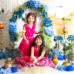Two sisters having fun during their Janmashtami photoshoot. Their bright smiles and colorful outfits are absolutely infectious.