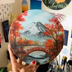 An autumn scene in Japan, featuring a snow-capped Mount Fuji, a traditional red bridge, and vibrant red foliage. This detailed landscape on a round canvas is perfect for anyone who loves Japanese aesthetics.