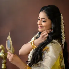 A beautiful detail shot of a mother dressed in a traditional Kerala saree, looking into an Aranmula Kannadi. These small moments of preparation are part of the story.