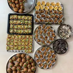 All the components for a fun party spread out and ready for packing. This includes mini burgers, pizza crackers, corn balls, fries, and doughnuts.