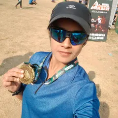 A participant proudly shows off her finisher's medal after completing her longest distance ever, 30km, at the Aravali Trail Run.