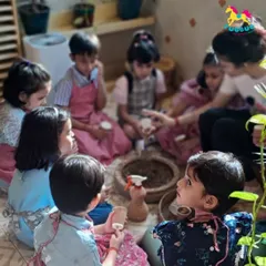 A group of children gather for a lesson on planting. I teach them how to handle seeds and soil, sparking an early interest in gardening and the environment.