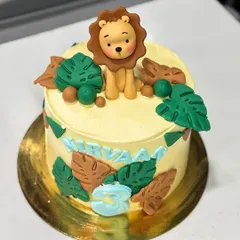 A top-down view of the jungle cake, showing the adorable fondant lion sitting amongst the edible leaves.