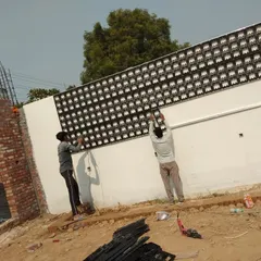 This image shows the installation of a much larger vertical garden frame on an exterior wall. You can see my team securing the extensive grid, preparing the foundation for what will become a large living wall.