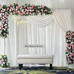 A beautiful example of a pink and white floral theme for an engagement. This setup uses a rectangular frame with an asymmetrical floral arrangement, a 'Better Together' neon sign, and a clean white backdrop for a fresh and modern feel.