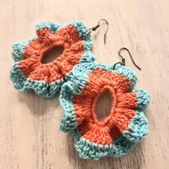 These two-tone floral earrings are another one of my crochet creations. The combination of orange and teal gives them a playful, vibrant look. I love how the open center makes them feel delicate and light.