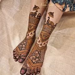 A beautiful and unique leg henna design done by my talented team. This piece features peacocks carrying umbrellas, a playful and elegant motif that adds a touch of whimsy to the traditional patterns.