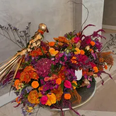 Diwali deliveries going out. This vibrant arrangement in shades of orange, pink, and purple is accented with a golden bird, making it a perfect, eye-catching centerpiece for your festive table.