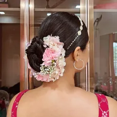 This sleek bridal bun is decorated with a beautiful arrangement of pink and white carnations and baby's breath. I also added a delicate matha patti for a touch of traditional elegance.