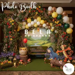 I design dedicated photo booths that continue the party's theme. This one features a rustic wooden bench set against a painted woodland backdrop, framed by a tree-like arch with balloons and character cutouts for memorable photos.