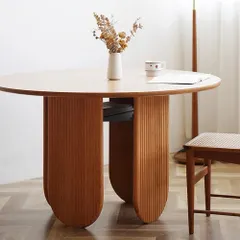 This farmhouse-style wood dining table offers a rustic charm and a natural feeling to your space. It features a smooth round tabletop and a textured pine wood base with a convenient open shelf for storage.