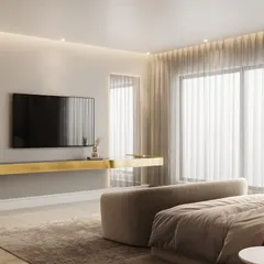 This view of the bedroom showcases the TV wall with a floating golden console, demonstrating a minimalist approach to functional elements. The lighting design includes both recessed spotlights and cove lighting.