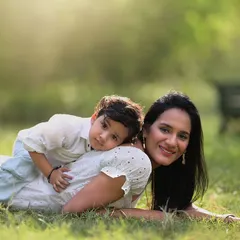 A tender moment between a mother and her son during an outdoor photoshoot. The relaxed, lying-down pose creates a sense of intimacy and comfort, perfect for a natural portrait.
