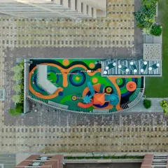 We believe community spaces should inspire joy. This aerial shot showcases the vibrant, custom-designed playground at PIXELSCAPES, where colorful, safe flooring and imaginative equipment create a hub of activity and fun for the community's youngest residents.
