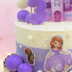 A close-up of the Sofia the First cake, showing the princess, her animal friends, and the purple castle details.