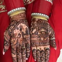 A traditional Karwa Chauth story on the palms. This design shows a woman carrying a pot on her head and a scene of a couple, capturing the essence of the festival.