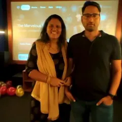 A happy couple enjoying their private screening. You can see our user-friendly interface on the screen behind them, where you can easily log into Netflix, Prime, Hotstar, and more.