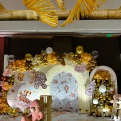 This teddy bear baby shower setup features a warm, golden color palette. The crescent moon prop and 'We Can Bearly Wait' backdrop, surrounded by gold and brown balloons, create a cozy and inviting atmosphere.