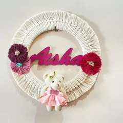A sweet and simple personalized name hoop for Aisha. This design includes a cute teddy bear and floral accents, making it a lovely welcome gift for a newborn.