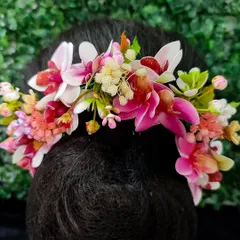 A lovely hair veni featuring a mix of pink and white orchids and other delicate blossoms. This accessory adds a fresh and romantic touch to any bridal hairstyle.
