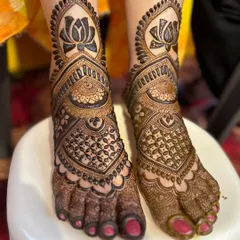 We love creating perfectly symmetrical designs for feet. Here, we've used bold lotus motifs as the centerpiece, surrounded by intricate geometric and traditional patterns that beautifully adorn the feet from ankle to toe.