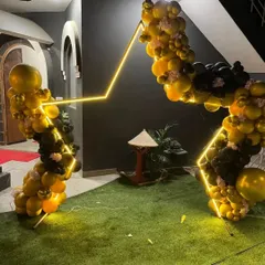 For a unique look, I designed this new star-themed backdrop using geometric frames with integrated LED lights and a black and gold balloon arch.