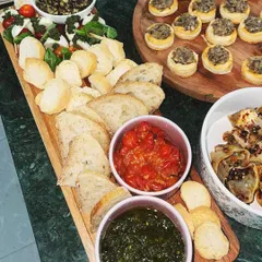 This long grazing board is perfect for sharing. It features a Caprese salad skewer, freshly baked bread, and my homemade pesto and roasted tomato dips. It’s a simple, fresh, and delicious way to start any meal.