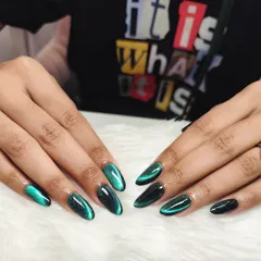 A deep and mysterious green cat eye effect. The magnetic polish creates a beautiful shimmer that moves with the light, giving these almond-shaped nails an enchanting, galaxy-like appearance.